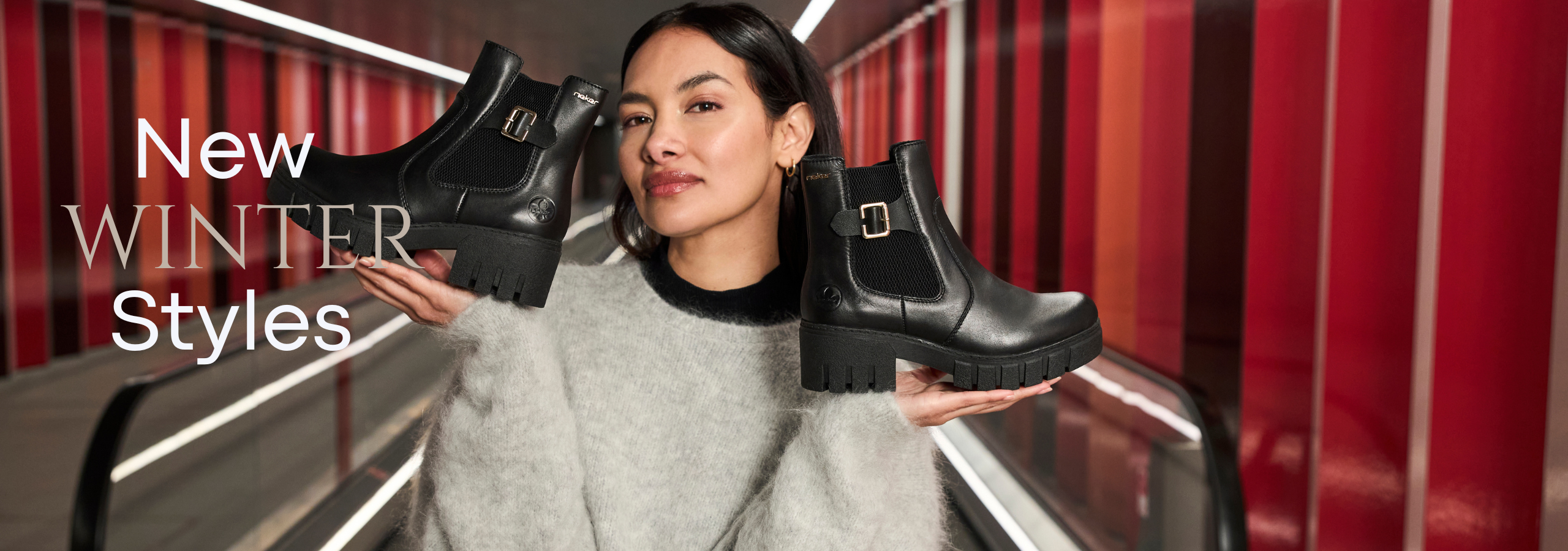 Woman holding black boots with a red and gray striped background and text 'New Winter Styles'.